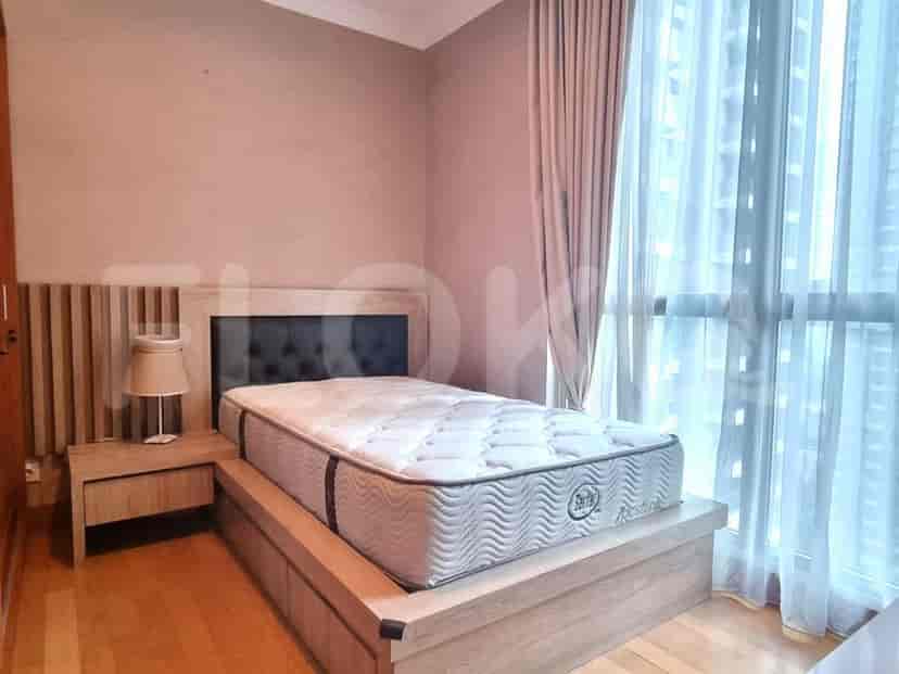 Bedroom with a bed and a nightstand next to a large window.