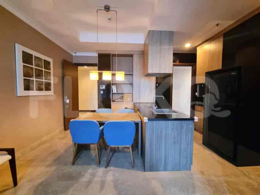 Modern open kitchen with wooden cabinets, a dining table, and a black countertop.