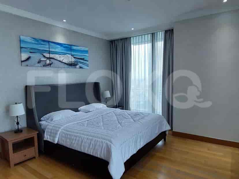 A master bedroom with a king bed, artwork, and a large window.