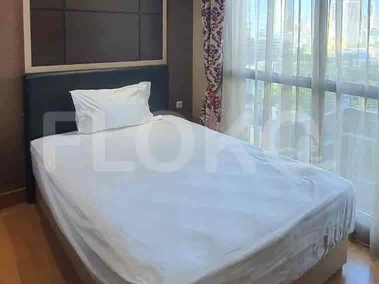 A small bedroom with a single bed and a view of the city.