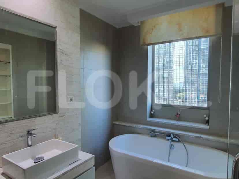 A bathroom with a bathtub, sink, and a window.