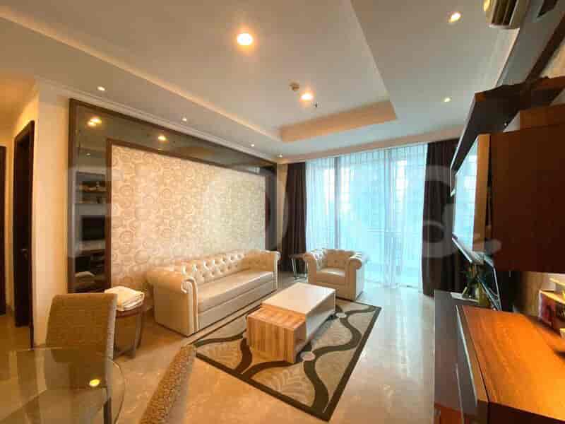 Living room with sofa, coffee table, TV, and window with curtains.