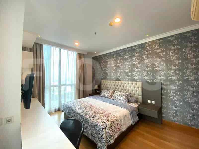 Bedroom with a king-sized bed, desk, and large window.