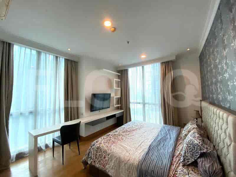 Bedroom with a king-sized bed, desk, and large window.