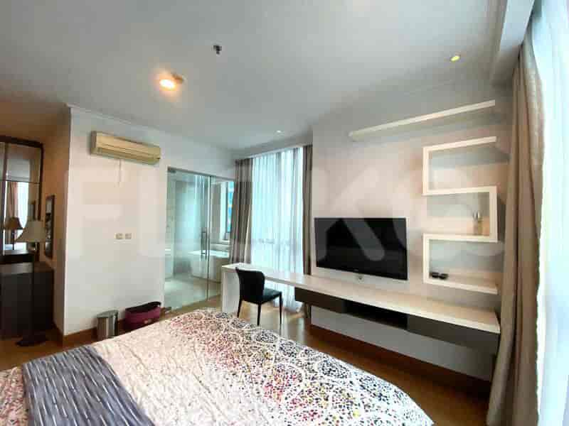 Bedroom with a king-sized bed, desk, and bathroom visible.