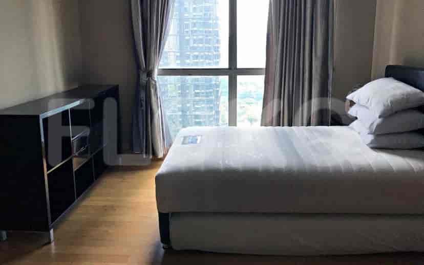 Cozy bedroom with a bed, storage unit, and window with city views.