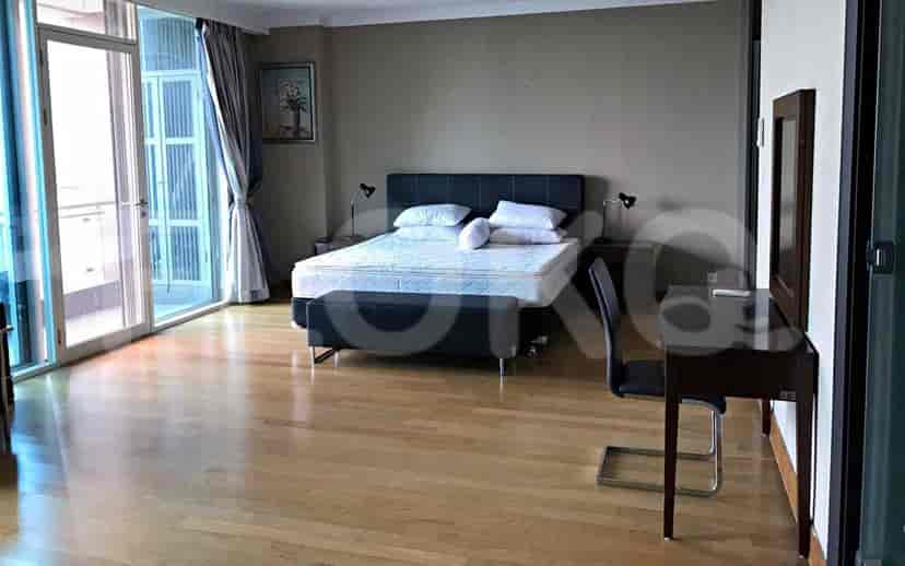 Spacious master bedroom with a king-size bed, desk, and balcony access.