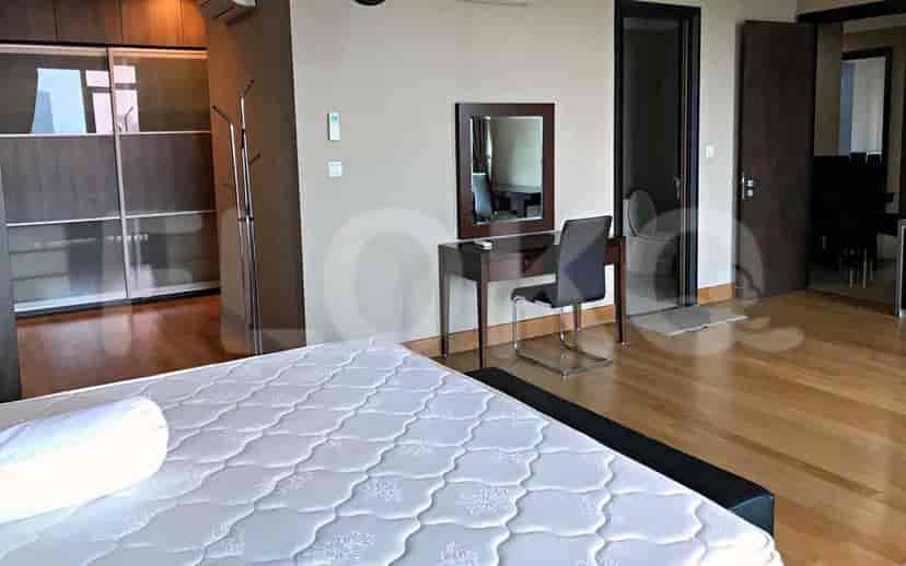 Bedroom featuring a bed with a headboard, a vanity area, and a closet.