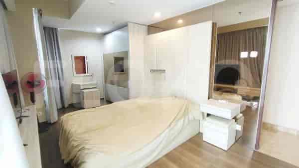 A modern bedroom with a large bed, built-in wardrobe, and a dressing table.