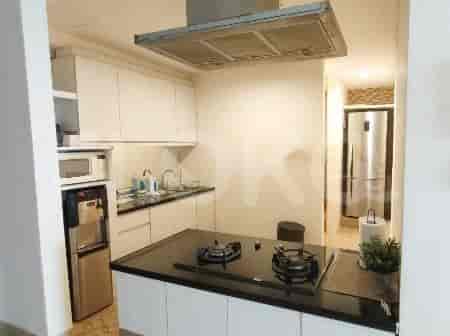 A contemporary kitchen with white cabinetry and a black countertop.