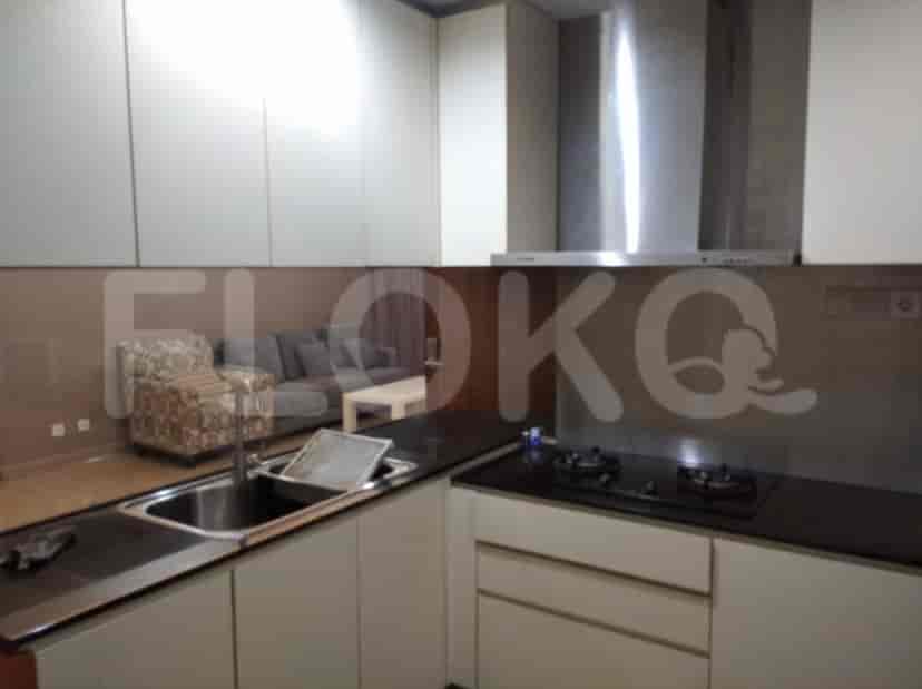 Dapur modern dengan tudung stainless steel, meja hitam, dan lemari putih.
