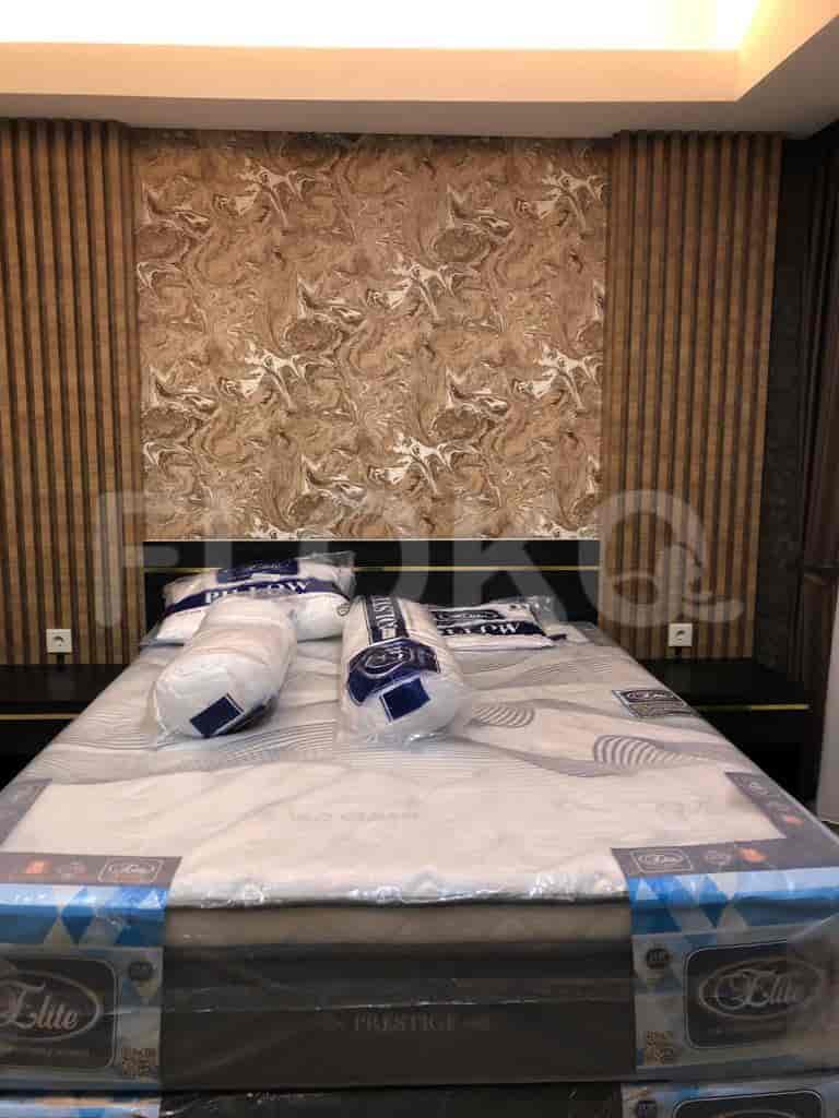 Kamar tidur dengan tempat tidur, TV yang dipasang di dinding, dan panel dinding dekoratif.