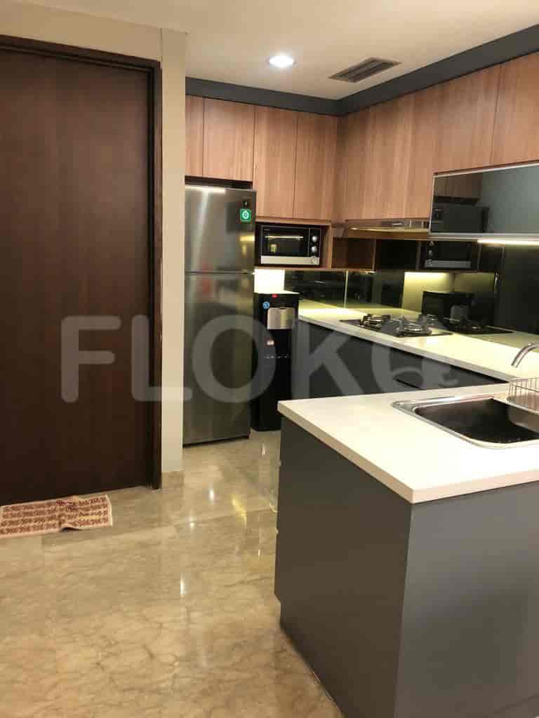 Dapur modern dengan lemari kayu, peralatan stainless steel, dan pulau abu-abu.