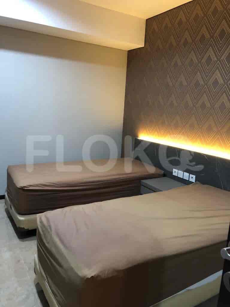 Tempat tidur kembar di kamar tidur dengan panel dinding dekoratif.