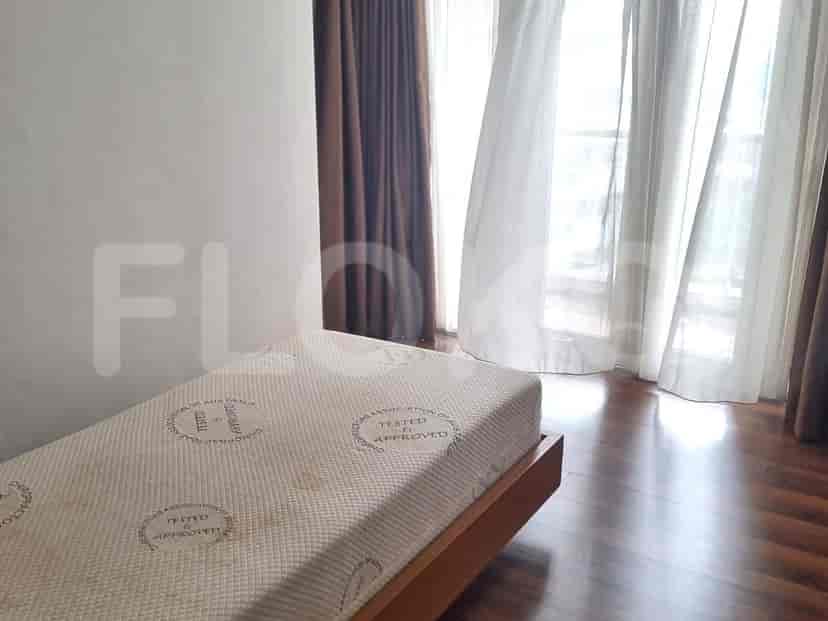 Bedroom with a single bed, wooden flooring, and curtains.