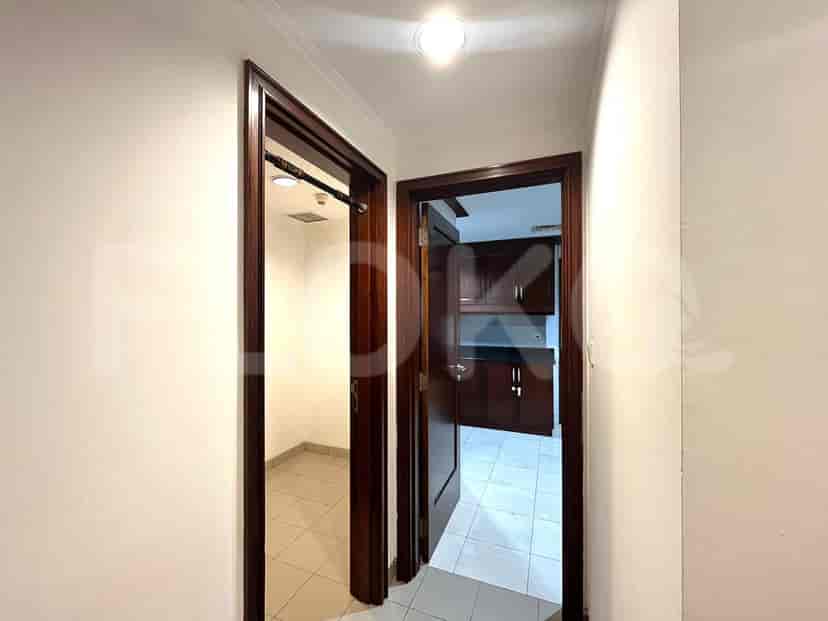 Hallway dengan pintu yang mengarah ke berbagai ruangan dan dinding putih.