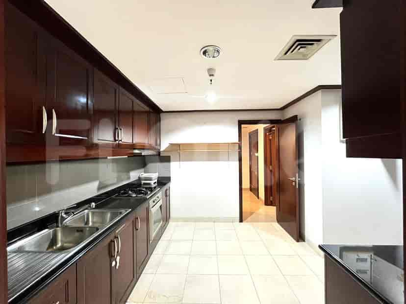 Dapur dengan lemari kayu gelap, peralatan baja tahan karat, dan lantai ubin.