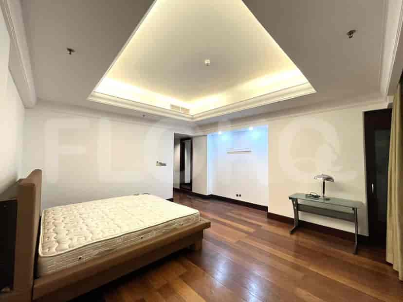 Kamar tidur dengan tempat tidur, lantai kayu, dan meja.