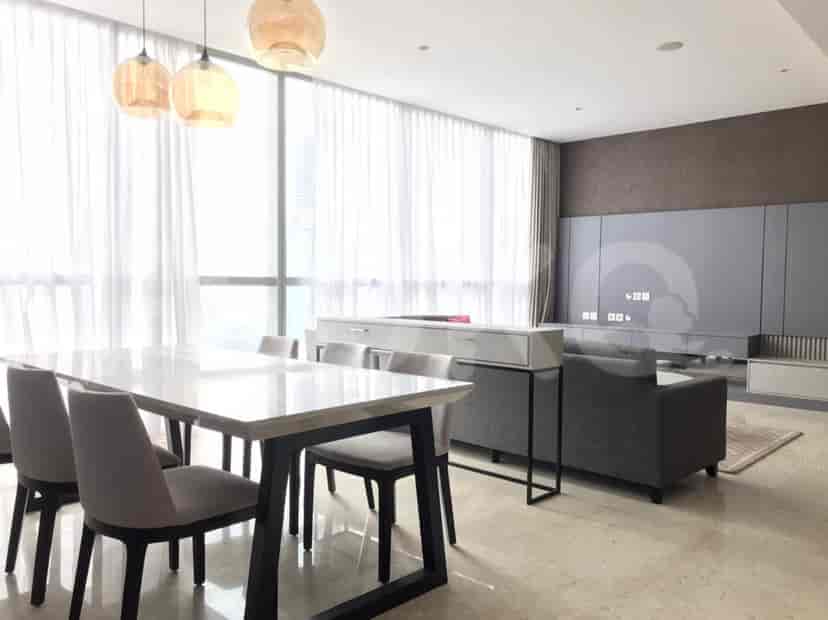 Open-plan living and dining area featuring a dining table with modern chairs and a TV console.