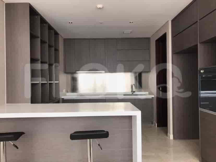 A modern kitchen featuring a central island, stainless steel accents, and dark wood cabinetry.