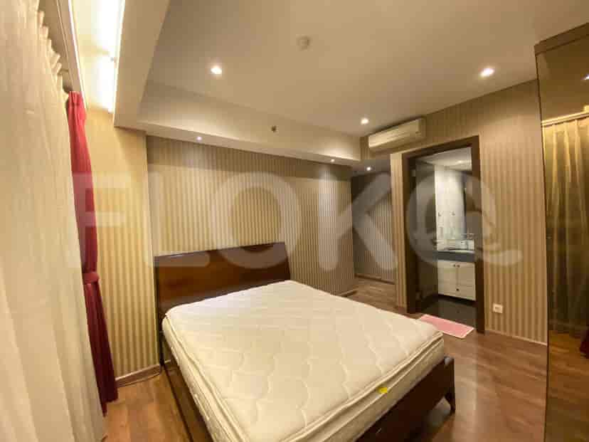 Kamar tidur yang menampilkan tempat tidur, meja samping, dan jendela.