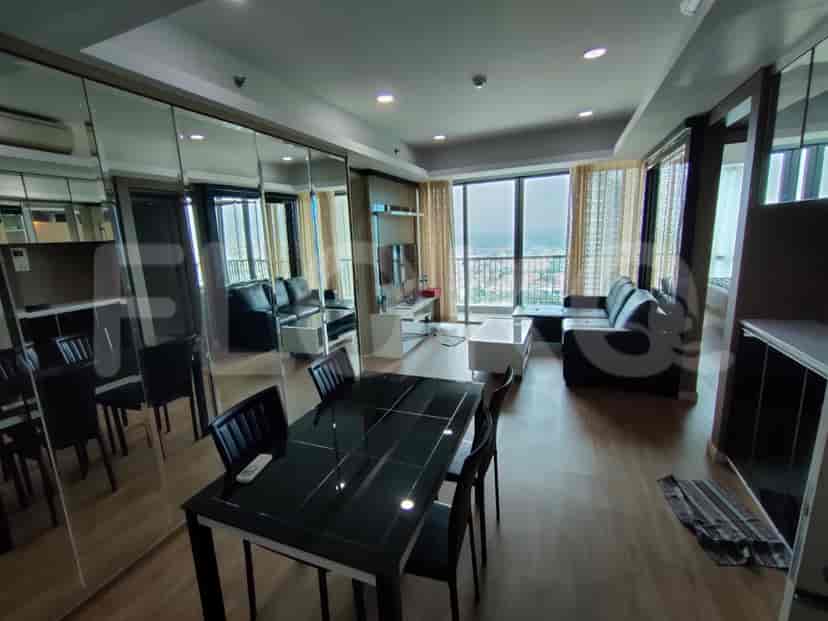 The dining and living areas are combined in a space, and feature a dining table and a view from the windows.