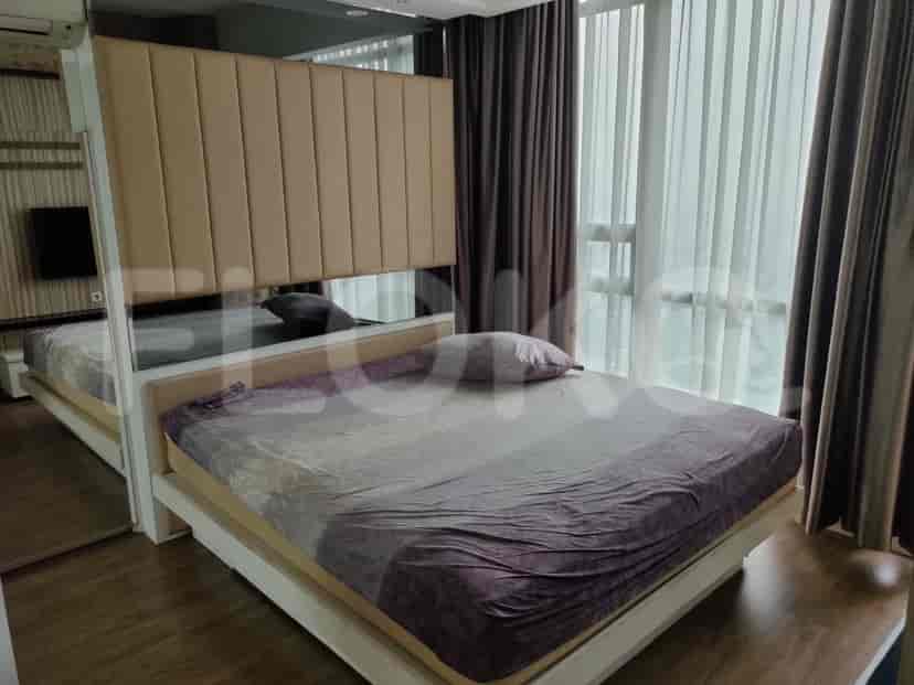 Elegant bedroom with a queen-sized bed, mirrored accents, and a warm, inviting aesthetic.