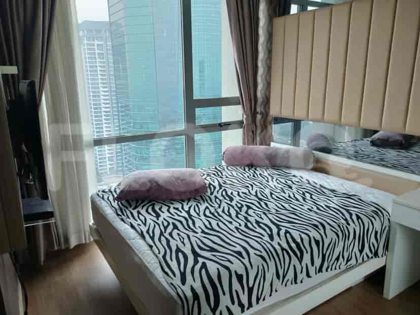 Bedroom with a modern bed, zebra print bedspread, and large windows with city views.