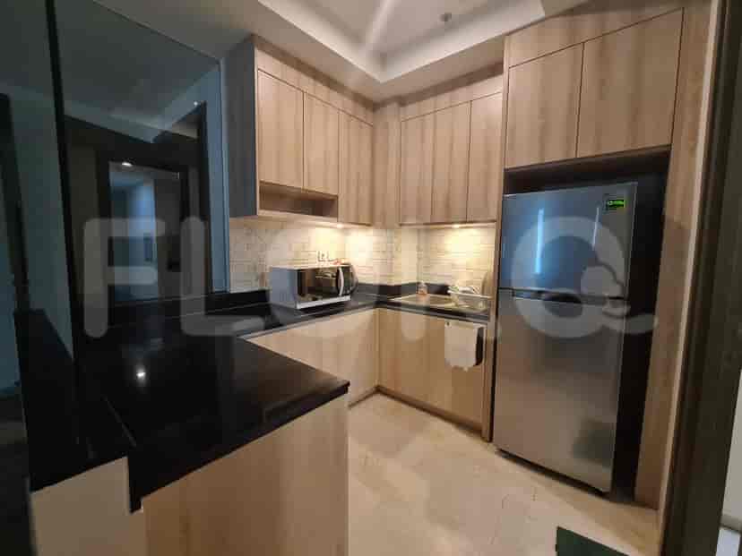 Dapur modern dengan lemari kayu, peralatan stainless steel, dan meja hitam.