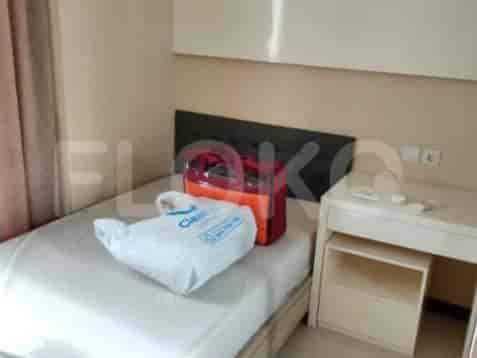 A bedroom with a single bed, desk, and a luggage.