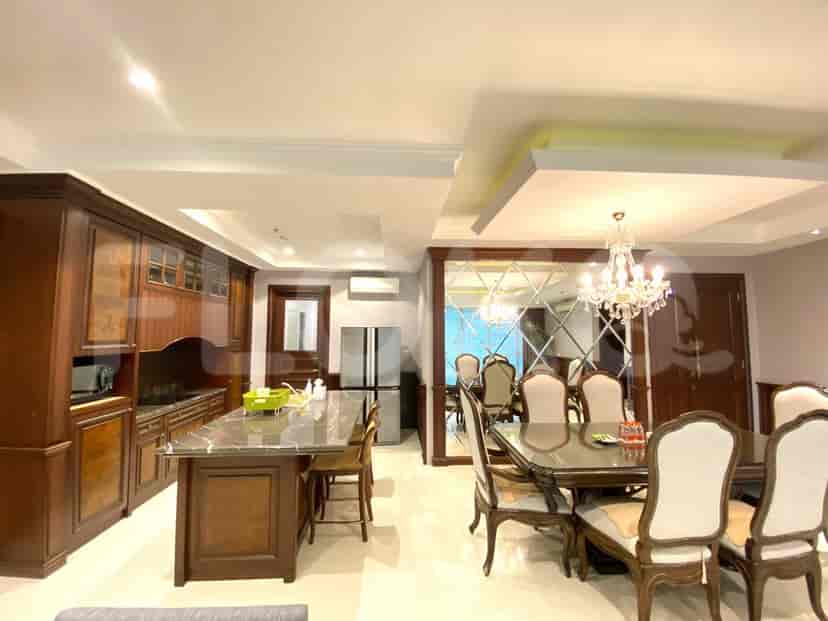 Dapur dengan pulau dapur, area makan, dan lemari kayu.