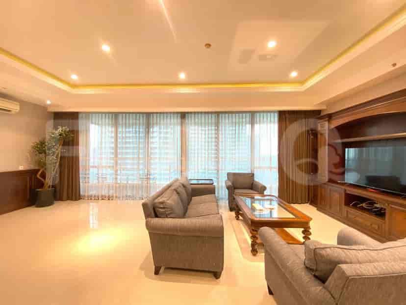 Ruang tamu dengan sofa, jendela besar, dan lemari built-in.