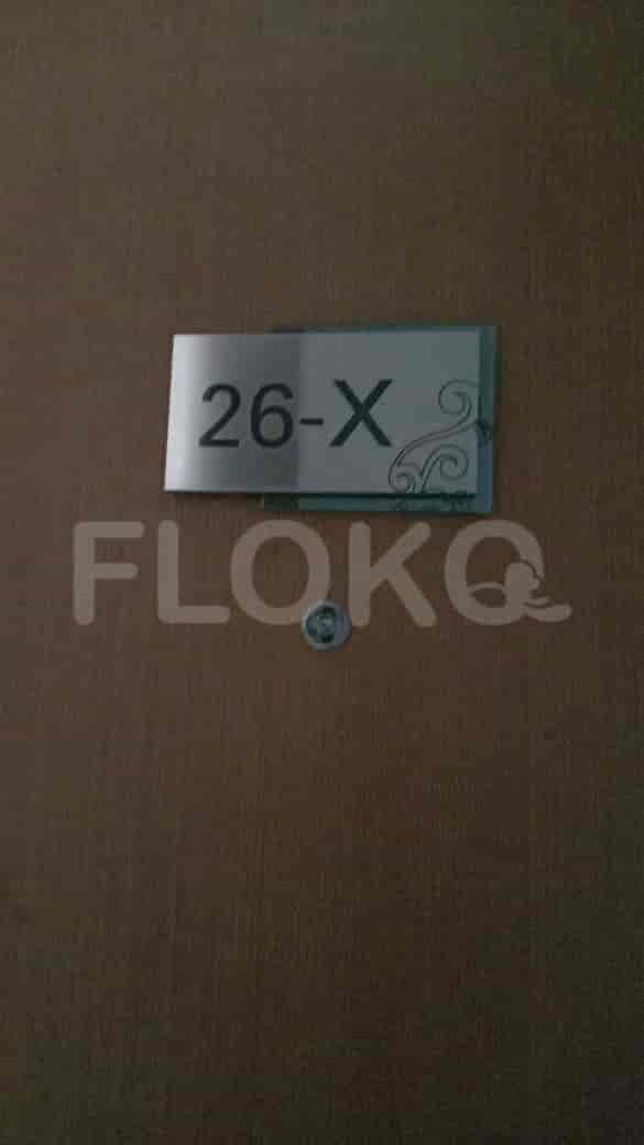 A wooden door with a room number sign.