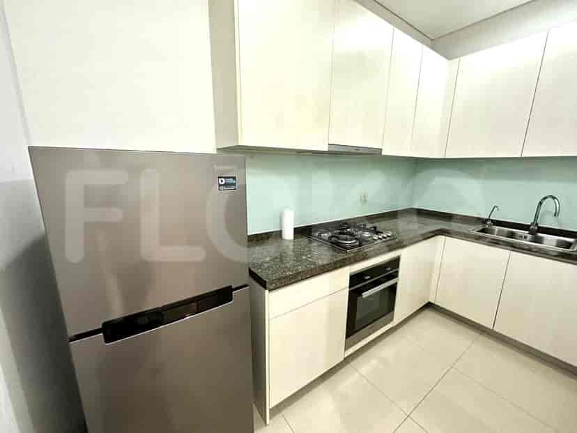 A modern kitchen with white cabinets, a stainless steel refrigerator, and a gas stove.