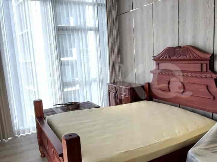 A bedroom with a bed and a side table.