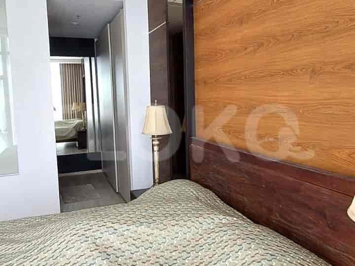 A bedroom with a bed and side table.
