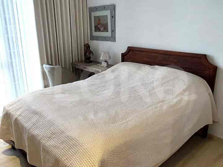 A bedroom with a bed and side table.