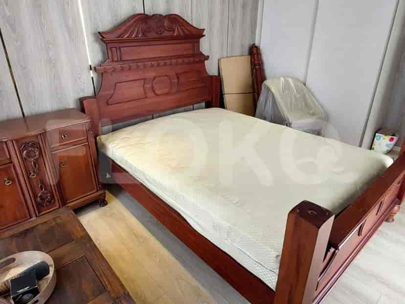 A bedroom with a bed and side table.