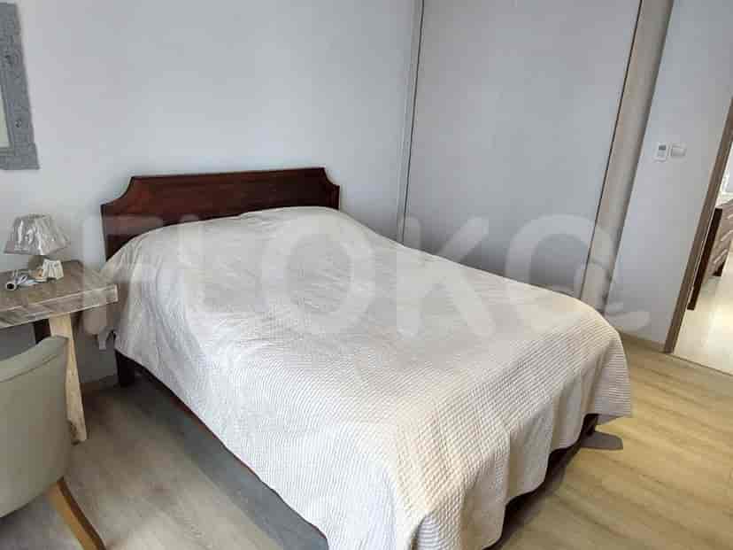 A bedroom with a bed and side table.