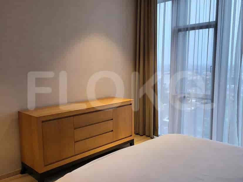 Bedroom with a wooden dresser, curtains, and a large window.