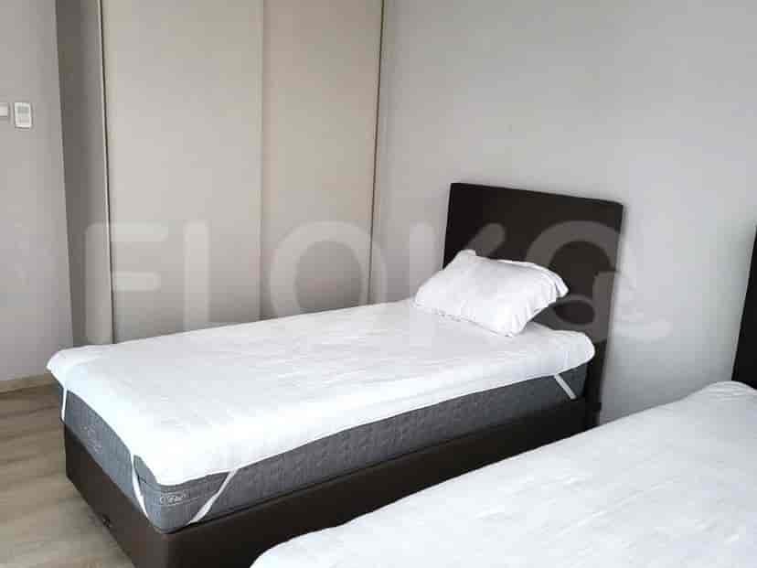 Bedroom with two twin beds, a wardrobe, and minimalist decor.