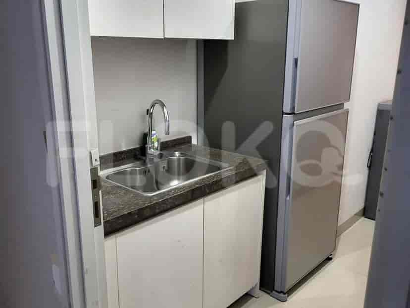 Small kitchen area with a sink, a refrigerator, and a microwave.