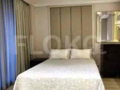 A bedroom with a bed, nightstand, and decorative headboard.