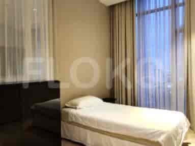 A bedroom with a single bed and a large window.