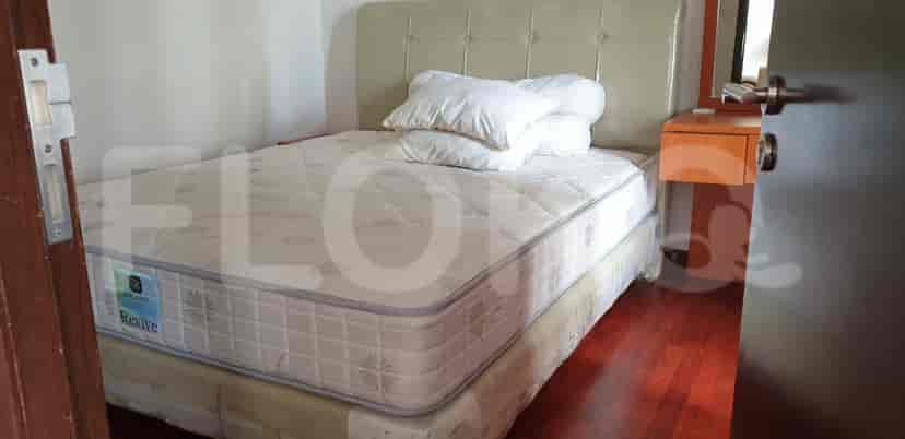 A bedroom with a queen bed, mirror, and vanity table.