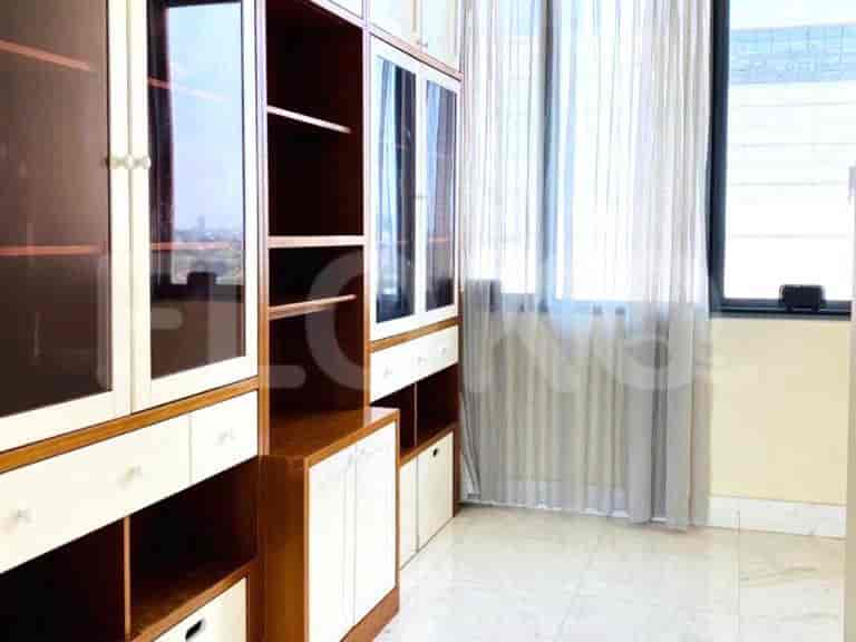 A large walk-in closet with extensive storage and glass-fronted cabinets.