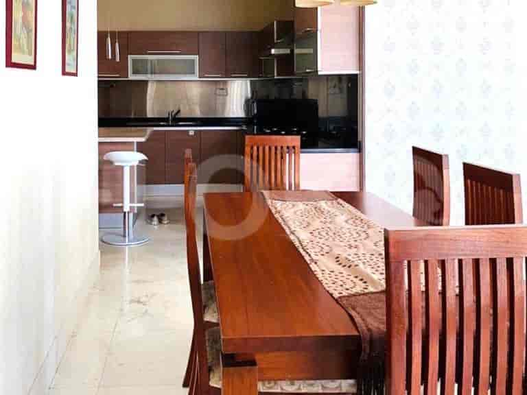 A dining area with a dining table, chairs, and an open kitchen.