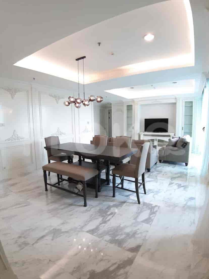 Elegant dining area with a dark wooden dining table, chairs, and a chandelier.