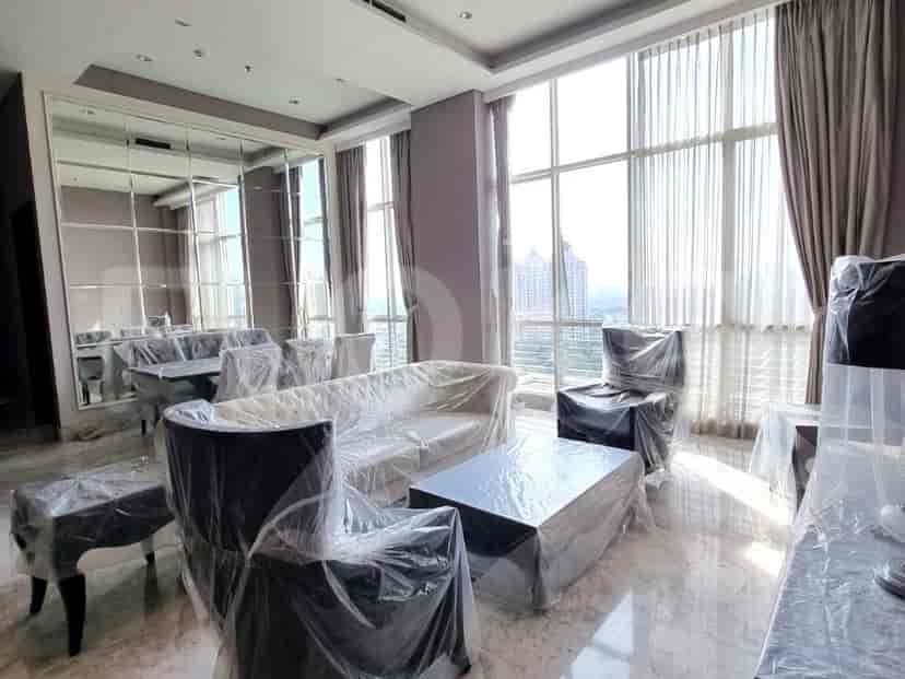 Living room with large windows, furniture covered in protective plastic, and a view of the city.
