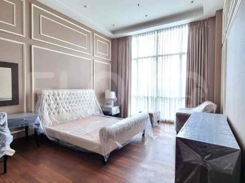 Bedroom featuring a bed, nightstands, and large windows with curtains.